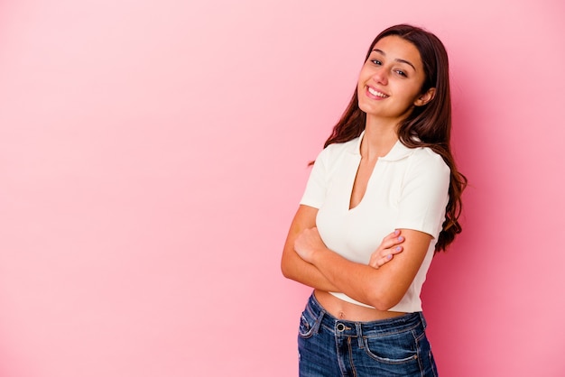 Jeune femme indienne isolée sur mur rose souriant confiant avec les bras croisés.