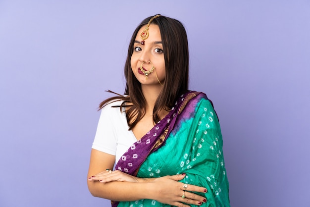 Jeune femme indienne isolée sur mur violet faisant des doutes geste tout en soulevant les épaules