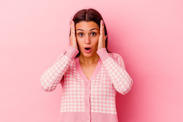 Jeune femme indienne isolée sur rose étant choquée, elle s'est souvenue d'une réunion importante.