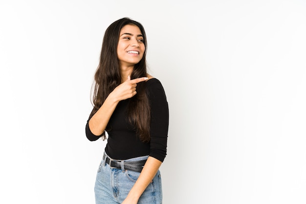 Jeune femme indienne isolée sur violet regarde de côté souriant, gai et agréable.