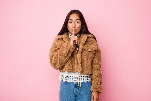 Jeune femme indienne métisse portant un manteau court en peau de mouton ou demandant le silence.