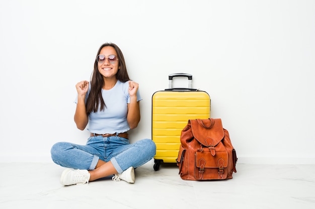 Jeune femme indienne métisse prête à partir en voyage en levant le poing, se sentant heureuse et réussie. Concept de victoire.