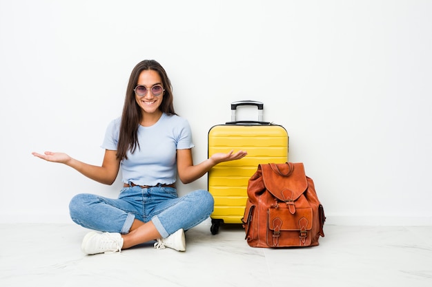 Jeune femme indienne métisse prête à partir en voyage montrant une expression bienvenue.