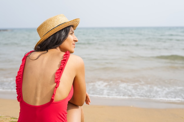 Jeune femme indienne à la recherche de la mer sur la plage