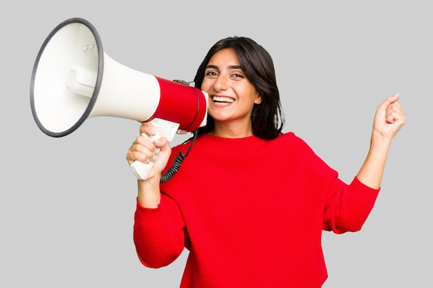 Jeune femme indienne tenant un mégaphone isolé