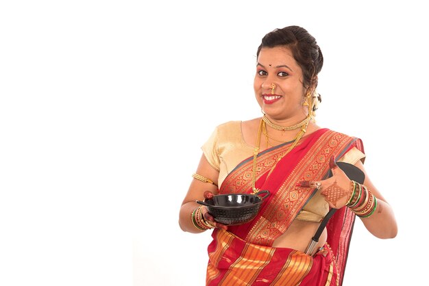 Jeune femme indienne traditionnelle tenant un ustensile de cuisine