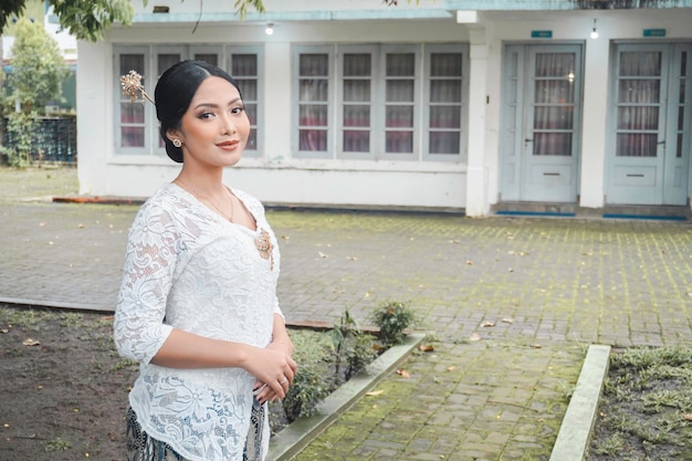 Une jeune femme indonésienne avec une heureuse expression réussie portant un kebaya blanc Kartini39s Day Concept