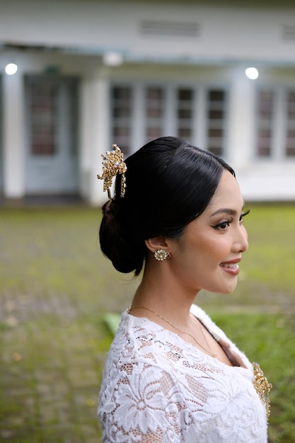 Une jeune femme indonésienne avec une heureuse expression réussie portant un kebaya blanc Kartini39s Day Concept