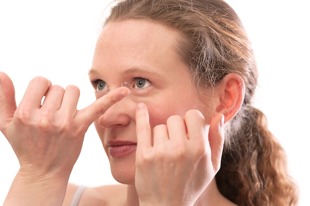 Photo jeune femme insérant une lentille de contact