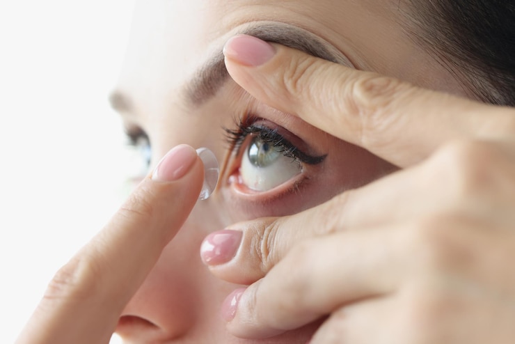 Photo jeune femme insérant des lentilles de contact dans son œil avec correction de la myopie en gros plan du doigt