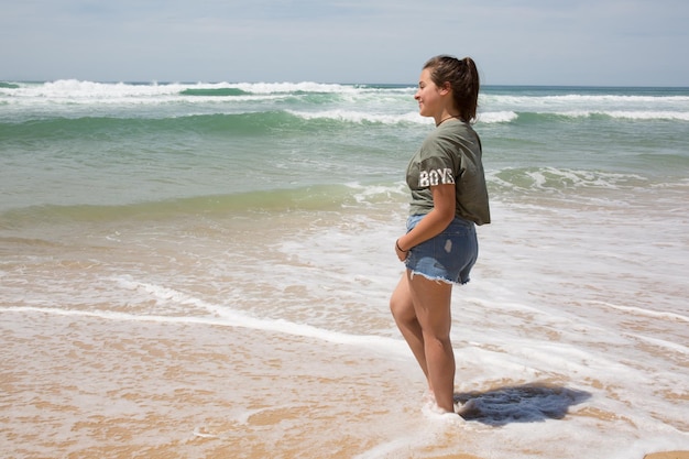 Jeune femme insouciante marchant dans l'eau de mer vacances à la plage se détendre concept de rêve de vie saine
