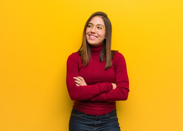 Jeune femme intellectuelle souriant confiant et croisant les bras, levant