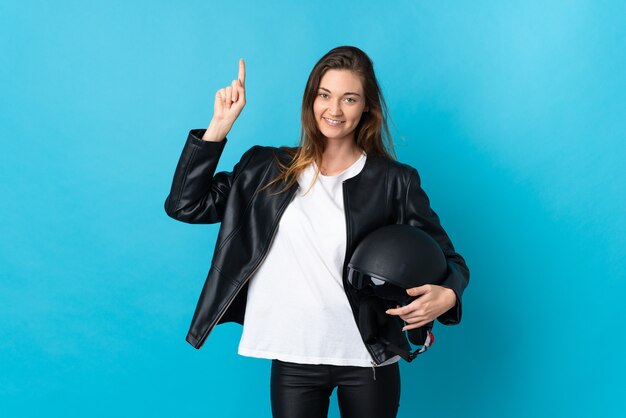 Jeune femme irlandaise tenant un casque de moto isolé sur fond bleu pointant vers une excellente idée