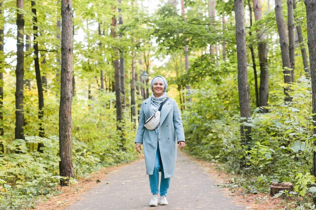 Jeune femme islamique portant le hijab debout sur fond de parc d'automne. Fille musulmane arabe moderne.