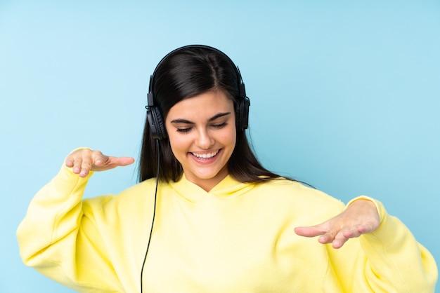 Jeune femme, sur, isolé, bleu, écoute, musique, et, danse