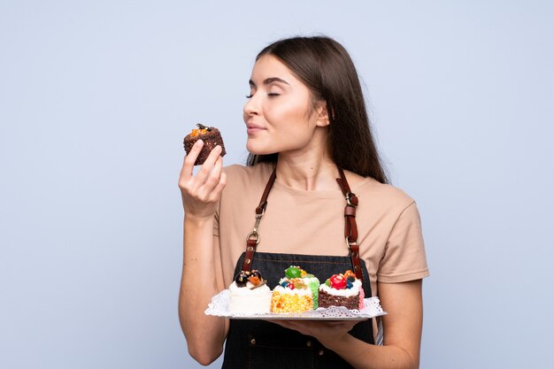 Jeune femme, isolé, bleu, tenue, mini, gâteaux