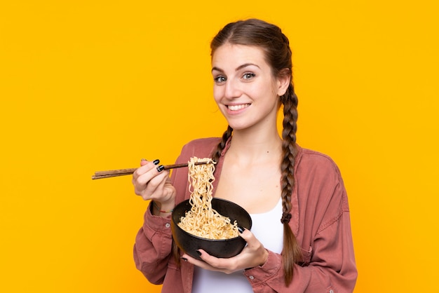 Jeune, femme, isolé, jaune, mur, tenue, bol, nouilles, baguettes