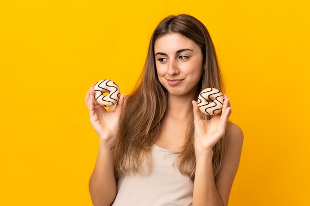 Jeune femme, sur, isolé, jaune, tenue, beignets