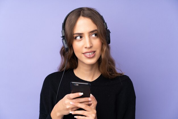 Jeune, femme, isolé, pourpre, mur, écoute, musique, mobile, pensée