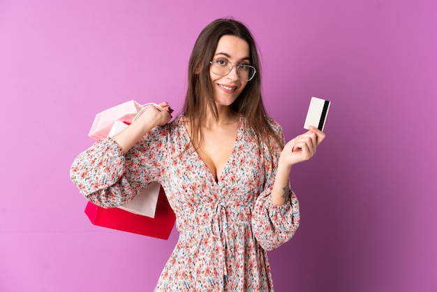 Jeune, femme, isolé, pourpre, mur, tenue, achats, sacs, crédit, carte