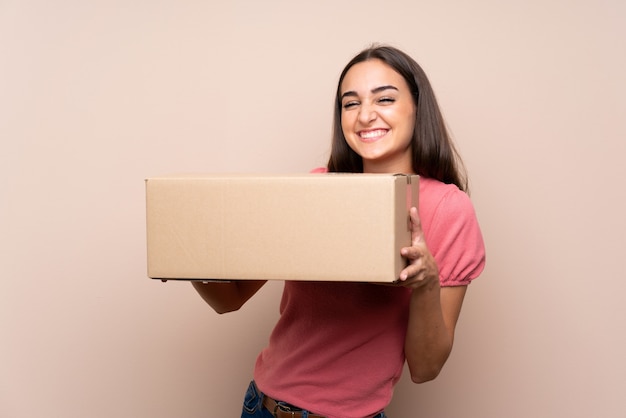 Jeune femme sur isolé tenant une boîte pour la déplacer vers un autre site