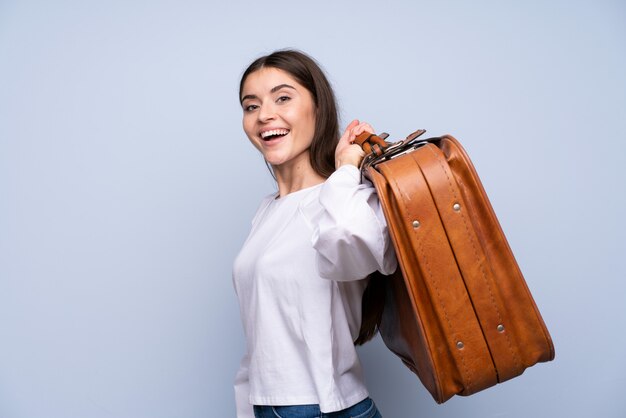 Jeune femme sur isolé tenant une mallette vintage