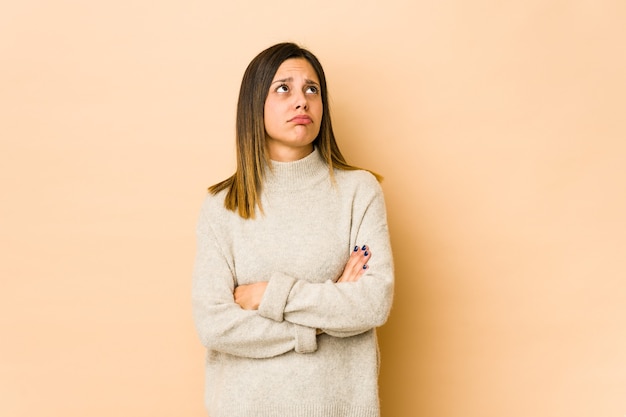 Jeune femme isolée sur beige fatiguée d'une tâche répétitive.