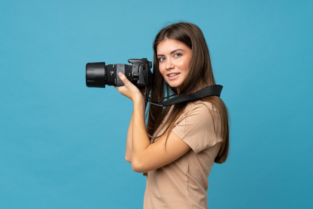 Jeune femme sur isolée avec une caméra professionnelle