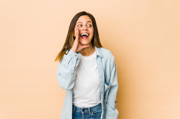 Jeune femme isolée sur des cris beiges excité à l'avant.