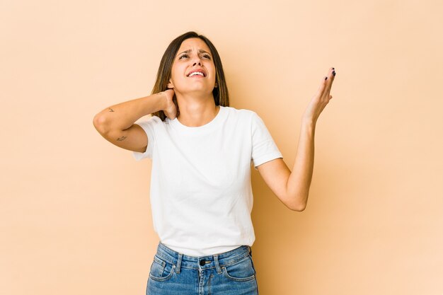 Jeune femme isolée sur fond beige hurlant de rage.