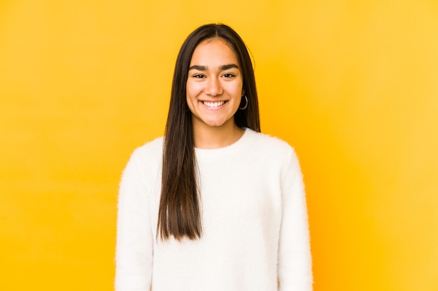 Jeune femme isolée sur un jaune heureux, souriant et joyeux.