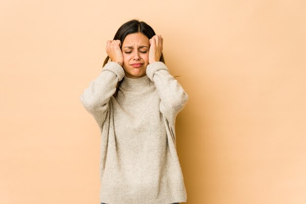 Jeune femme isolée sur un mur beige pleurant, mécontente de quelque chose, de l'agonie et de la confusion.