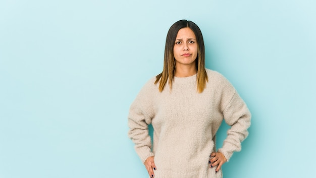 Jeune femme isolée sur un mur bleu visage triste et sérieux, se sentant misérable et mécontent.