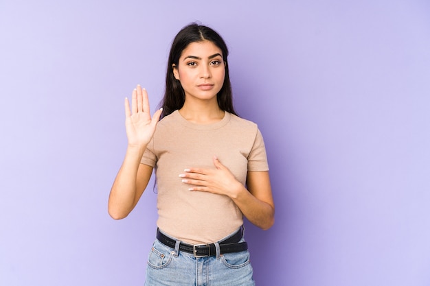 Jeune femme isolée sur violet prêtant serment