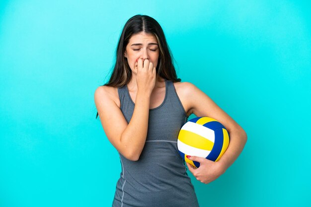 Jeune femme italienne jouant au volleyball isolé sur fond bleu ayant des doutes