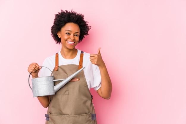 Jeune femme jardinier afro-américain souriant et levant le pouce vers le haut