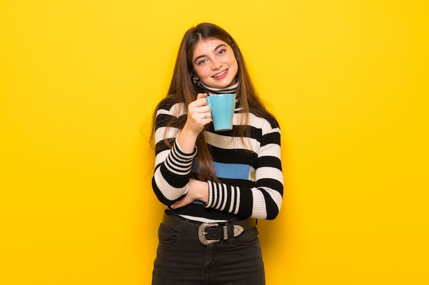 Jeune femme, sur, jaune, mur, tenue, a, chaud, tasse café
