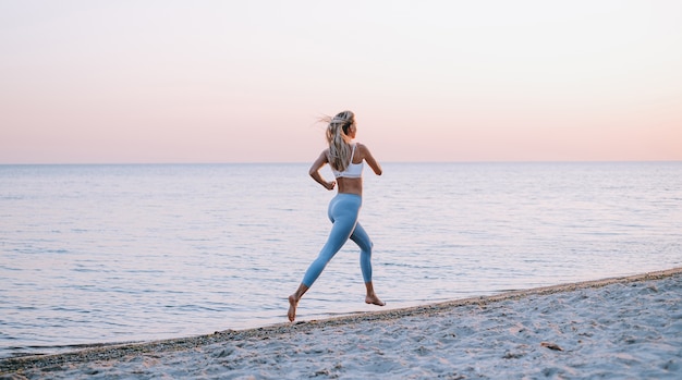 Jeune femme jogging au bord de l'océan