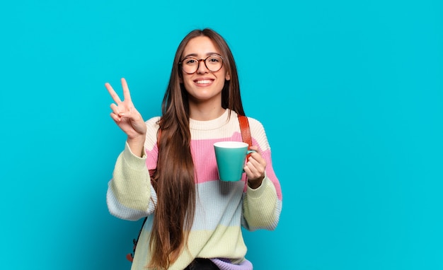 Jeune femme jolie étudiante avec une tasse de café