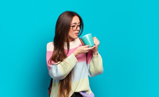 Jeune femme jolie étudiante avec une tasse de café