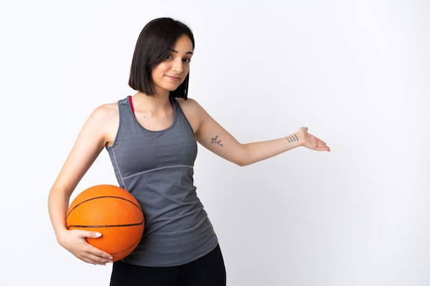 Jeune femme jouant au basket-ball sur blanc isolé s'étendant les mains sur le côté pour inviter à venir