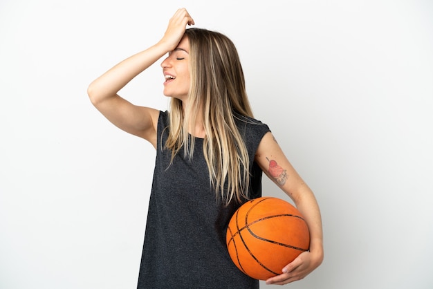 Une jeune femme jouant au basket-ball sur un mur blanc isolé a réalisé quelque chose et envisage la solution