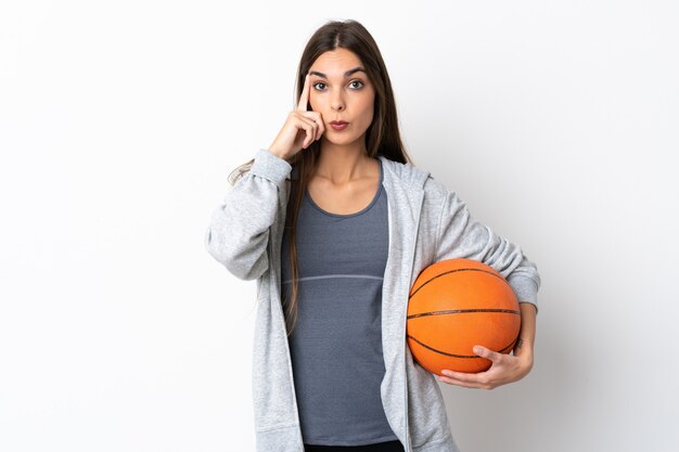 Jeune femme jouant au basket sur blanc pensant une idée