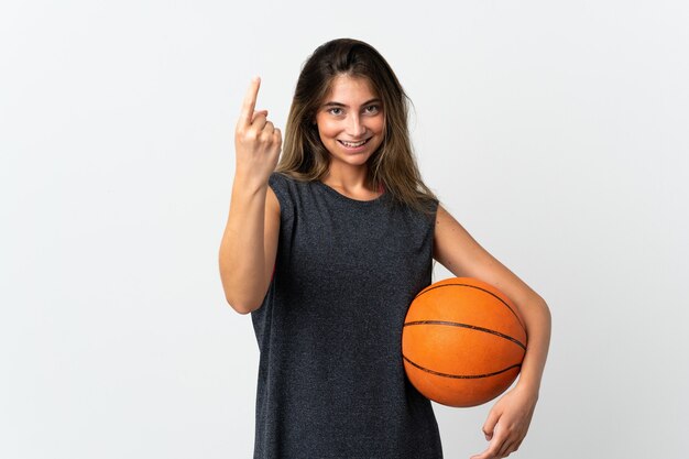 Jeune femme jouant au basket isolé sur mur blanc faisant le geste à venir