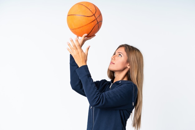 Jeune femme jouant au basketball sur isolé