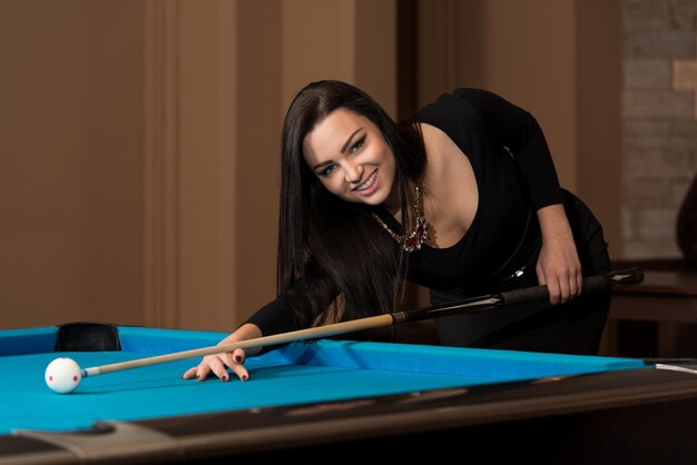 Jeune femme jouant au billard alignés pour tirer facile coup gagnant