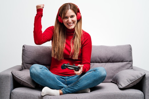 Jeune femme jouant à des jeux vidéo à la maison