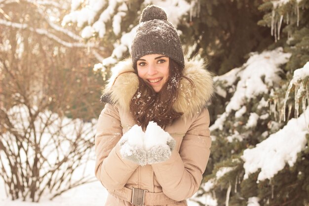 Jeune femme jouant avec de la neige et s'amusant