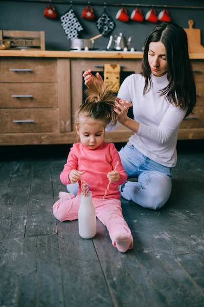 jeune femme jouant avec sa petite fille dans la cuisine.