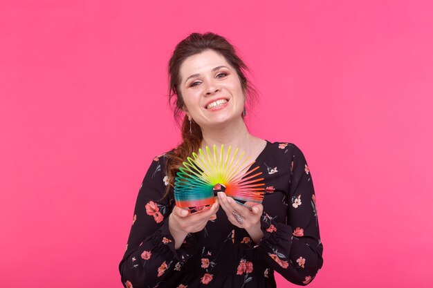 Jeune femme jouant avec un slinky sur fond bleu